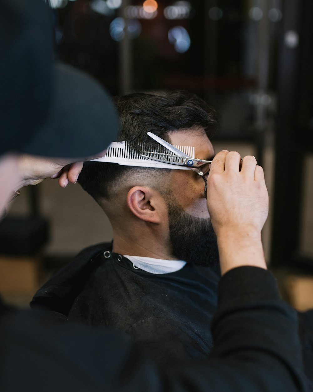 Barbero recortando con tijera y peine