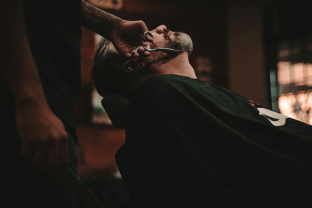 Barbero afeitando a un cliente con navaja