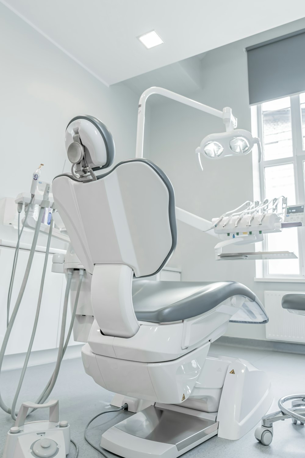 Sillón dental blanco junto a una ventana luminosa